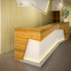 Reception desk in a waiting room with wooden and white angled design